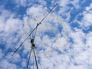 VHF radio antenna with stay ropes against cloudy sky photo