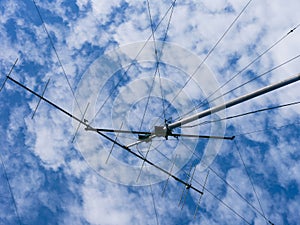 VHF radio antenna with a stay ropes against cloudy sky photo
