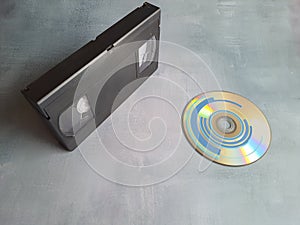 VHS video tape and DVD CD on gray background. photo