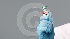 Vial With Coronavirus Covid-19 Vaccine In Hand Of Doctor In Blue Gloves