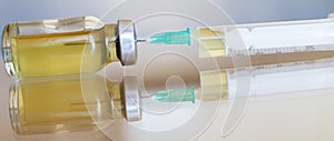 Vial filled with liquid vaccine in medical lab with syringe. medical ampoule and syringe on the glass surface. banner