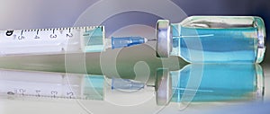 Vial filled with liquid vaccine in medical lab with syringe. medical ampoule and syringe on the glass surface. banner