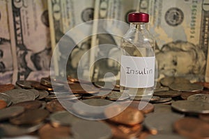 A vial of Insulin standing on a pile of Cash