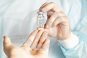 Vial with new usa, american vaccine for covid-19 coronavirus, flu, infectious diseases. Hand reaches to doctor. Injection after