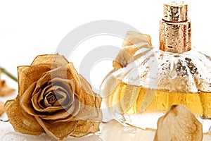 Vial of perfume and dry rose flower