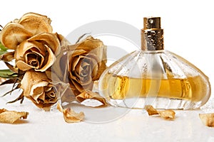 Vial of perfume and dry rose flower