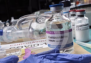 Vial of sodium pentobarbital next to an oxygen mask, covid-19 pandemic