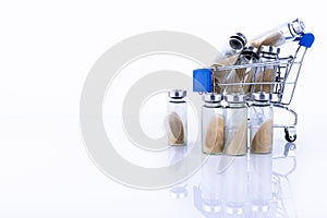 Vials, ampoules with dry probiotic, bifidobacteria inside, in the shopping cart. against the background of belrm. Copy space