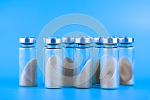 Vials, ampoules with dry probiotic, bifidobacteria, with probiotic powder inside on a blue background. Copy space