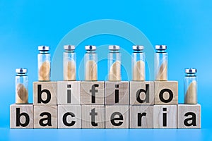 Vials, ampoules with dry probiotic, bifidobacteria, with probiotic powder inside on a blue background. Copy space