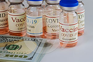 Vials glass bottle of American vaccine Sars-Cov-2, COVID-19 Coronavirus with of dollars many US bills the USA flag in the