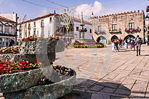 Viana do Castelo PORTUGAL - August 5, 2021 - Selective focus on flower pots in the PraÃÂ§a da RÃÂ©publica with fountain and monument