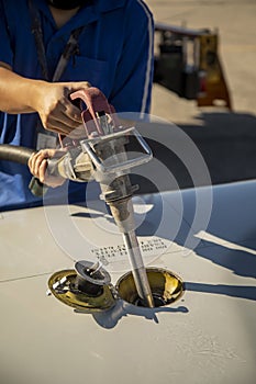 Viation fuel being pumped into wing tank of a small airplane