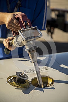 Viation fuel being pumped into wing tank of a small airplane