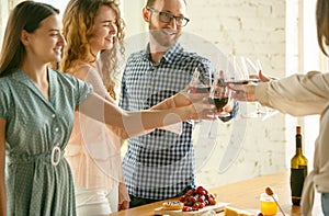 People clinking glasses with wine or champagne. Happy cheerful friends celebrate holidays, meeting. Close up shot of