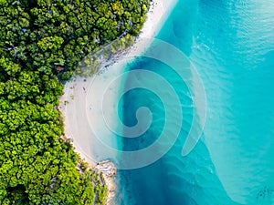 A vibrant aerial view of the beach with blue water