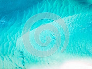 A vibrant aerial view of the beach with blue water