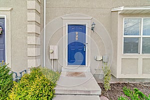 Vibrant blue front door at the entrance of an apartment house with bay window