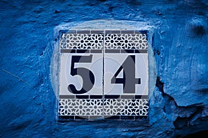 Vibrant blue house post: Numbers adorn this eye-catching house post, creating an intriguing focal point against the vivid blue