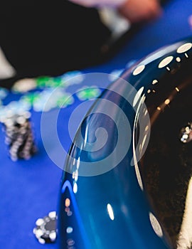 Vibrant casino table with roulette in motion, with casino chips, tokens, the hand of croupier, dollar money and a group of