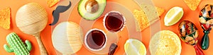 A vibrant Cinco de Mayo-inspired flat lay featuring a sombrero, maracas, tequila shots, lime, chili peppers, nacho chips on a photo