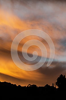 Vibrant cloudy sky at sunset over a town.