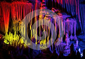 Vibrant colored cave formations illuminated by dramatic lighting