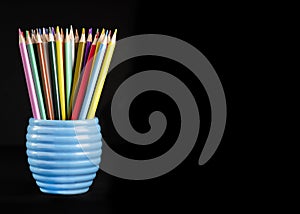 vibrant colored pencils on a jug on a black background shot for copy space and text over lay