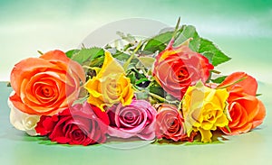 Vibrant colored (red, yellow, orange, white) roses flowers, close up, bouquet, floral arrangement, green background