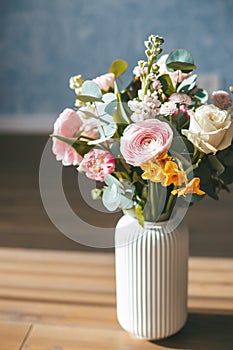 A vibrant and colorful bouquet of assorted flowers in a white vase