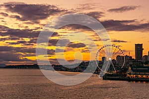 Vibrant and colorful Seattle skyline waterfont with the Great or Ferris Wheel at sunset or dusk from Elliott Bay, Washington state