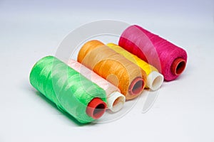A vibrant, 45-degree shot of five spools of thread.