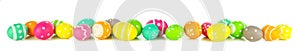 Vibrant Easter eggs forming a long border isolated on white