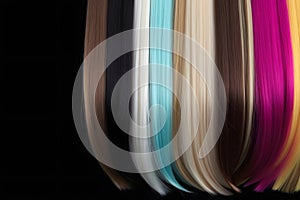 Vibrant Hair Extensions Flow in an Array of Rainbow Colors Against a Black Background