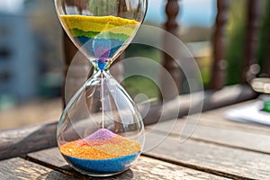 vibrant hourglass with rainbow colored sand flowin - generated by ai