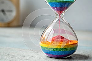 vibrant hourglass with rainbow colored sand flowin - generated by ai