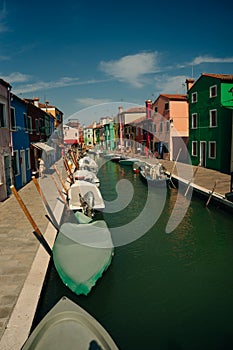 Vibrant houses along a boat lined canal in Burano, Venice, Italy - nov, 2021