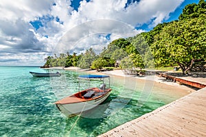 Small motorized boat at the pier and beach of Cayo Levantado Island, Samana Bay, Dominican Republic. photo