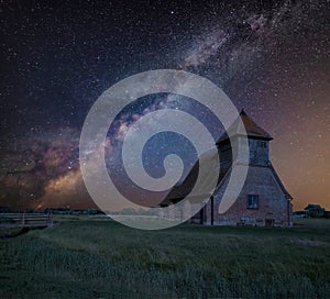 Vibrant Milky Way composite image over landscape of Ancient Medieval church