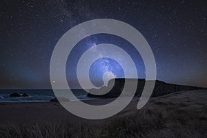 Vibrant Milky Way composite image over landscape of headland and ocean