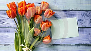 Vibrant Orange Tulips with Blank Greeting Card on Blue Wooden Background