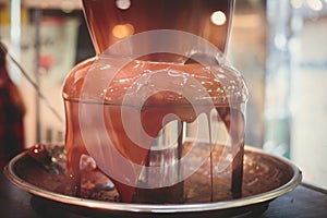 Vibrant Picture of Chocolate Fountain Fontain on childen kids birthday party with a kids playing around and marshmallows and fruit