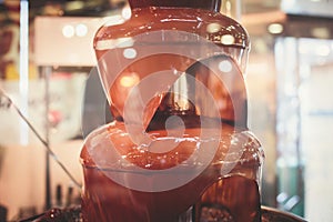 Vibrant Picture of Chocolate Fountain Fontain on childen kids birthday party with a kids playing around and marshmallows and fruit