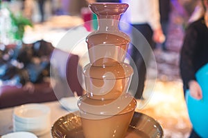 Vibrant Picture of Chocolate Fountain Fontain on childen kids birthday party with a kids playing around and marshmallows and fruit