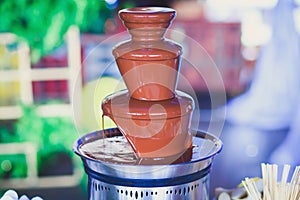 Vibrant Picture of Chocolate Fountain Fontain on childen kids birthday party with a kids playing around and marshmallows and fruit