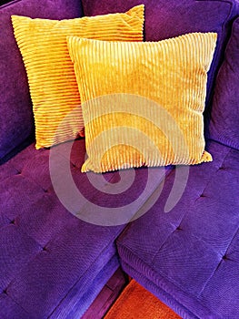 Vibrant purple sofa with orange cushions