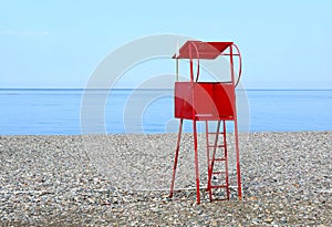 Vibrant red lifeguard chair on the empty beach