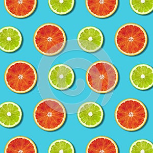 Vibrant red orange and green lime lemon slices pattern on turquoise background