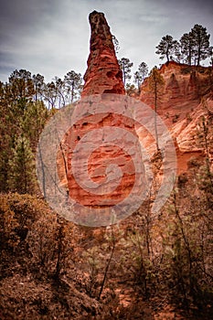 Vibrant red rock formations in the picturesque village of Roussillon in Provence, France