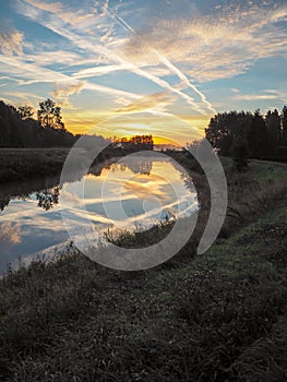 Vibrant reflection of the sun and blue sky in the river Dyle in Mechelen